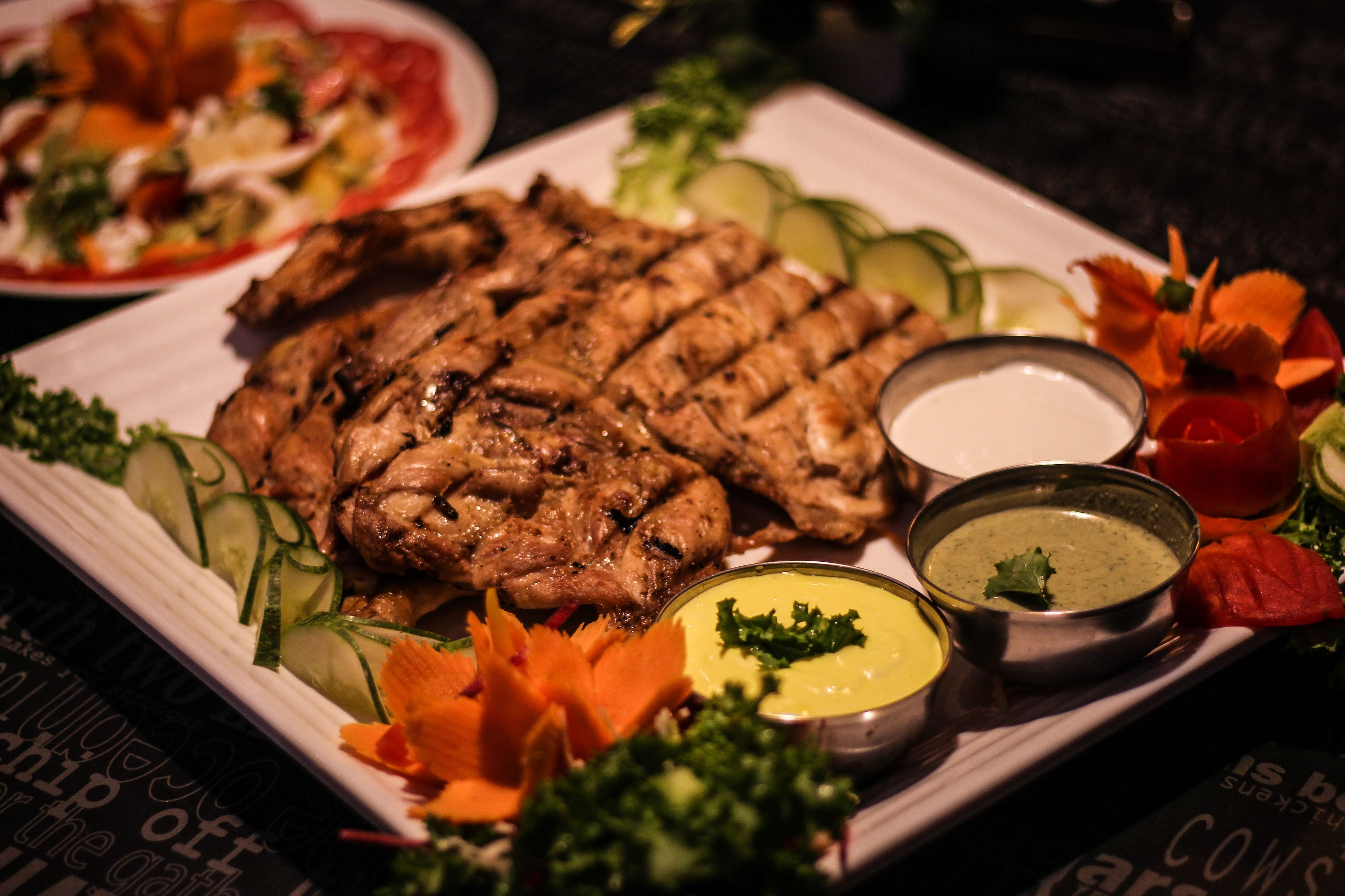 Grilled chicken with dips and garnish at Mandi@36